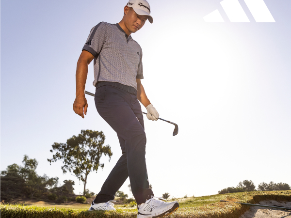 Image of a man walking on a golf course.