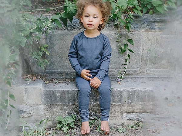 Child wearing a Woolino Kids'' Merino Wool Thermal Top & Legging in Charcoal gray.