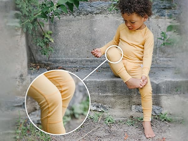 Child wearing Woolino Kids'' Merino Wool Thermal Top & Legging in Honey yellow.