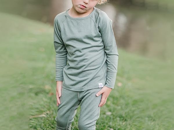 Child wearing Woolino Merino Wool Thermal Base Layers in Sage green.