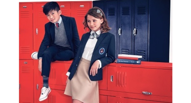 girl and boy in front of red and black lockers posing in school uniforms