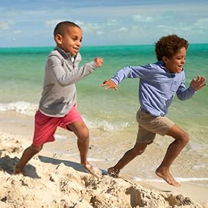 Two boys running on the beach while wearing Vineyard Vines.